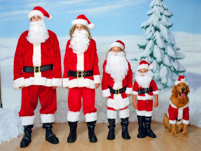 Family and pet dog wearing Santa costumes. Christmas.