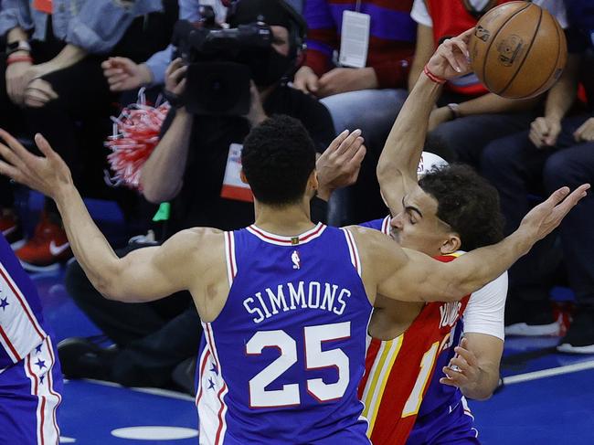 PHILADELPHIA, PENNSYLVANIA - JUNE 16: Trae Young #11 of the Atlanta Hawks passes between Ben Simmons #25 and Seth Curry #31 of the Philadelphia 76ers during the second quarter during Game Five of the Eastern Conference Semifinals at Wells Fargo Center on June 16, 2021 in Philadelphia, Pennsylvania. NOTE TO USER: User expressly acknowledges and agrees that, by downloading and or using this photograph, User is consenting to the terms and conditions of the Getty Images License Agreement.   Tim Nwachukwu/Getty Images/AFP == FOR NEWSPAPERS, INTERNET, TELCOS & TELEVISION USE ONLY ==