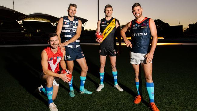 North Adelaide's Alex Spina, South Adelaide's Tyson Brown, Glenelg's Luke Reynolds and Norwood's Mitch Grigg wearing blue socks to help raise awareness for MND. Picture: Morgan Sette