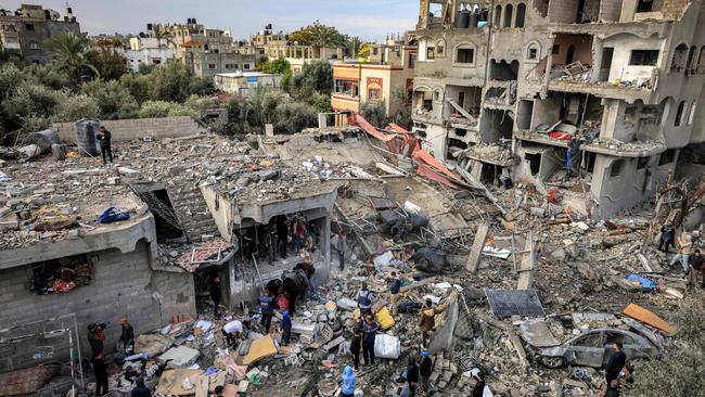 Men recover the body of a victim killed in the aftermath of an overnight Israeli strike at al-Maghazi refugee camp on December 25, 2023. Picture: Mahmud Hams/AFP