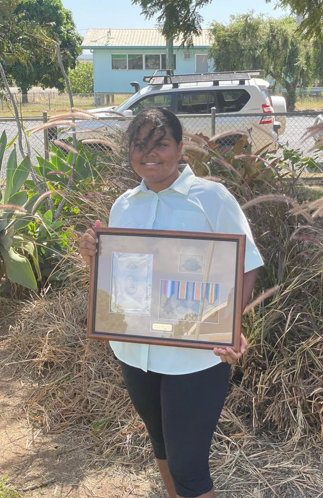 St Lawrence Primary School student Ngarie proudly displays war medals from the community as a part of the town’s inaugural Anzac Day ceremony in town. Picture: Mitchell Dyer