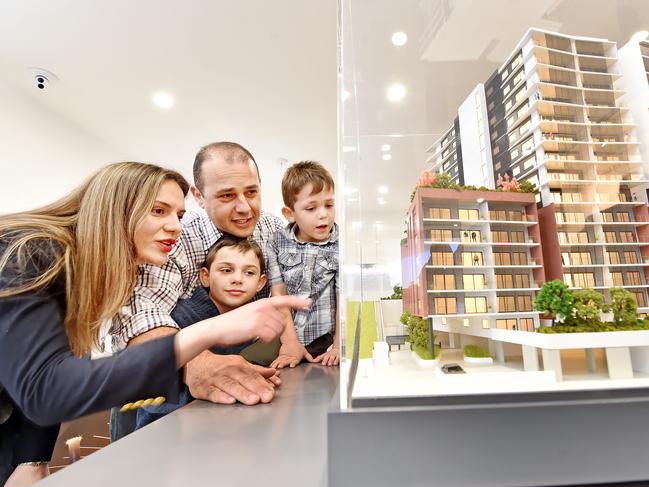 Sasha & Zobair Bary and their boys Timur, 9, and Artyom, 5, inspect a scale model at the Merindah Apartments display suite at Gosford on Friday August 10th. Real estate case study for a story about buying property off the plan. (AAP IMAGE / Troy Snook)