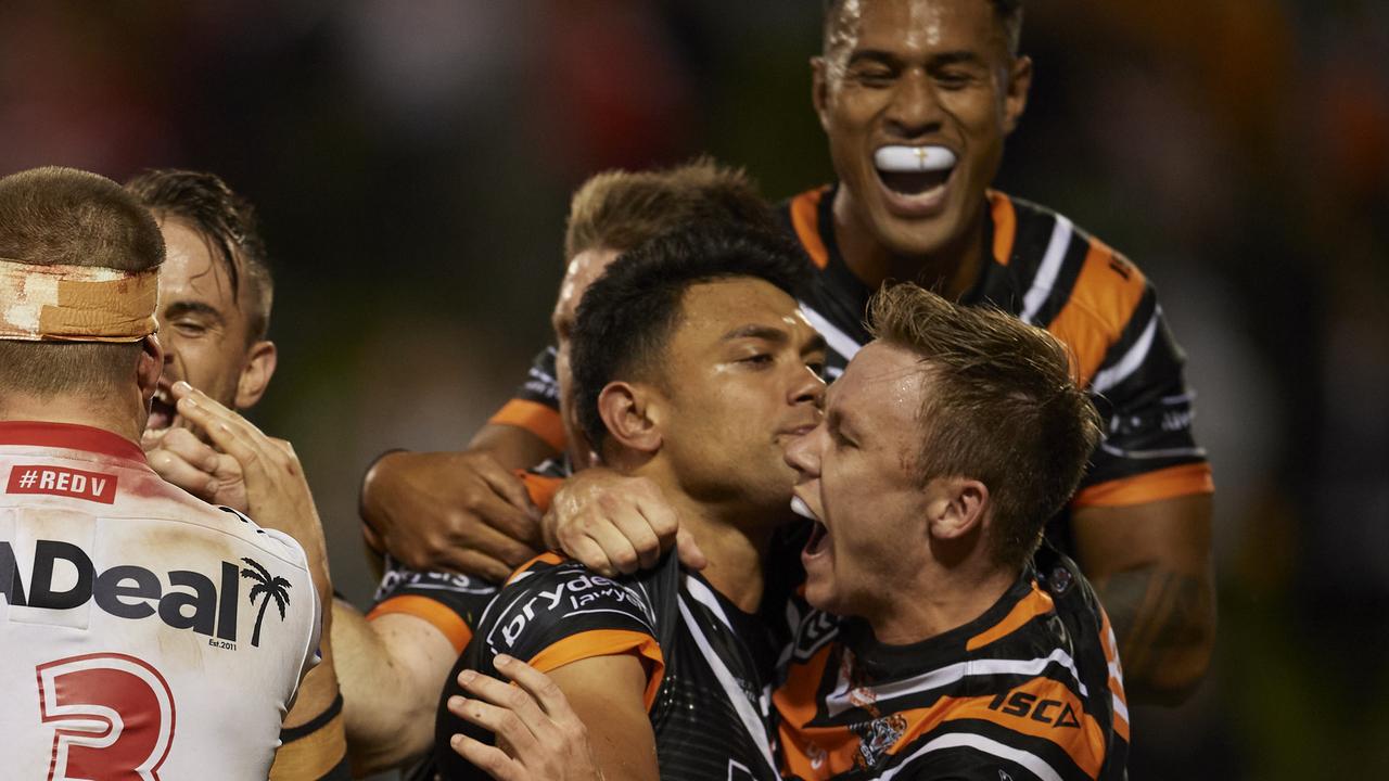 Wests Tigers celebrate after the matchwinning try. (Photo by Brett Hemmings/Getty Images)