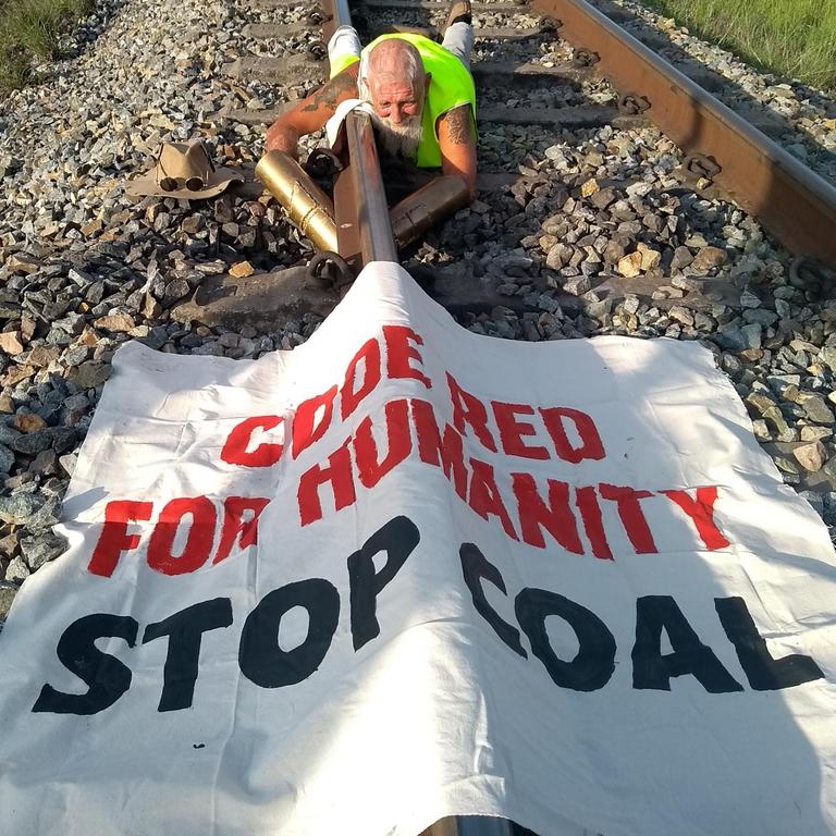 Jeffrey Cantor locked himself to the track on the Newlands rail line, stopping Adani’s train from moving. Picture: Frontline Action on Coal.