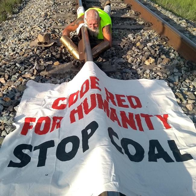 Jeffrey Cantor locked himself to the track on the Newlands rail line, stopping Adani’s train from moving. Picture: Frontline Action on Coal.