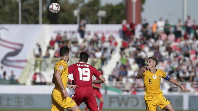 Australian midfielder Mark Milligan and Palestine forward Mahmoud Wadi fight for the ball. Picture: AP