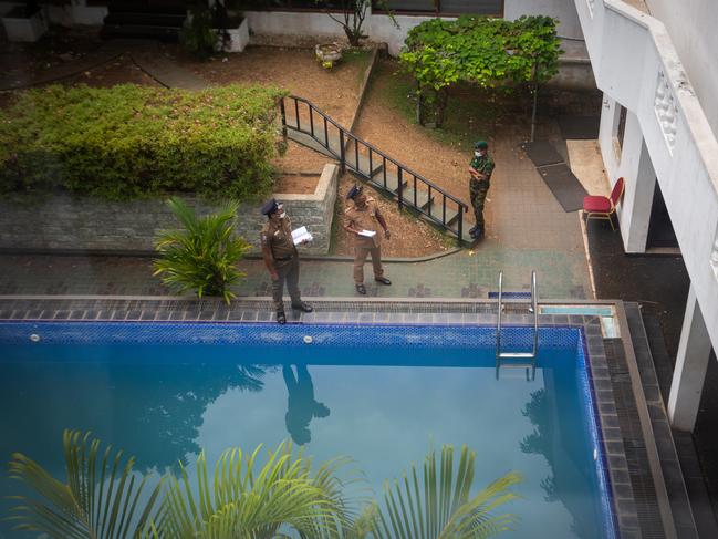 Police personnel look for forensic evidence near a swimming pool inside the Sri Lankan president's official residence on Friday. Picture: Getty Images