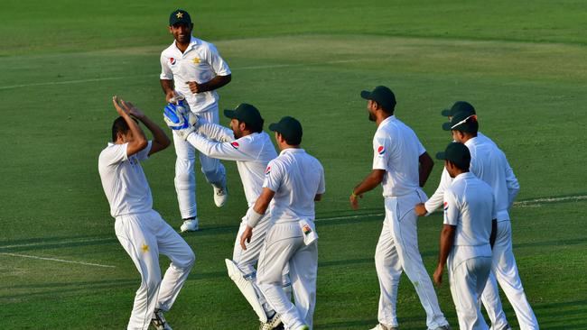 Pakistan cricketer Muhammed Abbas (left) celebrates with teammates after the late dismissal of Usman Khawaja. Picture: AFP