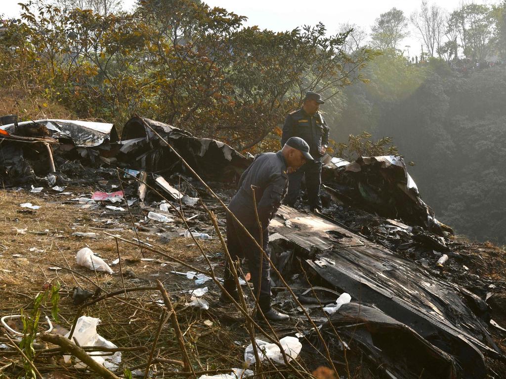 Rescuers inspect the wreckage at the site of a plane crash in Pokhara, Nepal, in the Himalayan country's deadliest aviation disaster in three decades. Picture: AFP