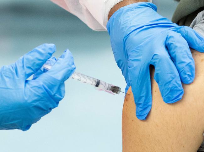 (FILES) In this file photo a man receives a dose of the Moderna coronavirus disease (COVID-19) vaccine at a vaccination site at South Bronx Educational Campus, in the Bronx New York on January 10, 2021. - US biotechnology firm Moderna on January 25, 2021 said lab studies showed its Covid-19 vaccine would remain protective against variants of the coronavirus first identified in the United Kingdom and South Africa. "The study showed no significant impact" on the level of neutralizing antibodies elicited against the UK variant, B.1.1.7. (Photo by Kena Betancur / AFP)