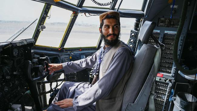 A Taliban fighter sits in the cockpit of an Afghan Air Force aircraft at Kabul’s Hamid Karzai International airport on Tuesday. Picture: AFP