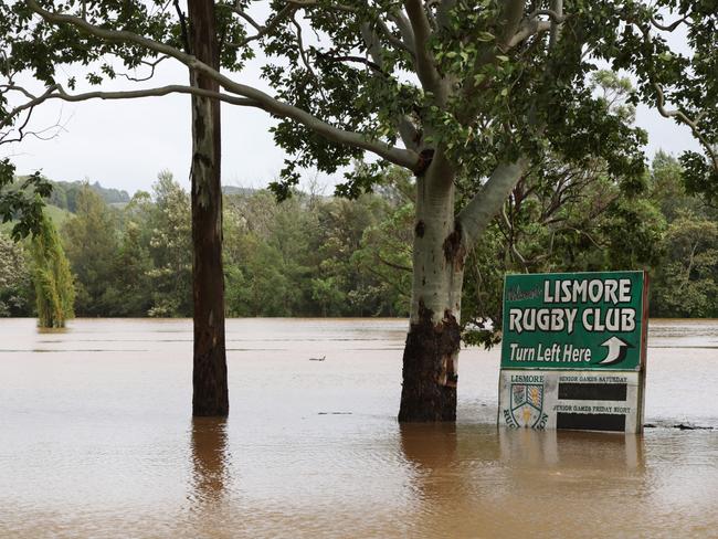 Flood waters lapping this Lismore Rugby Club sign. Picture: Matrix/ Nathan Smith