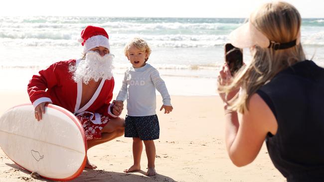 One of the many locals grabbing a snap with Surfing Santa. Picture: Tim Hunter