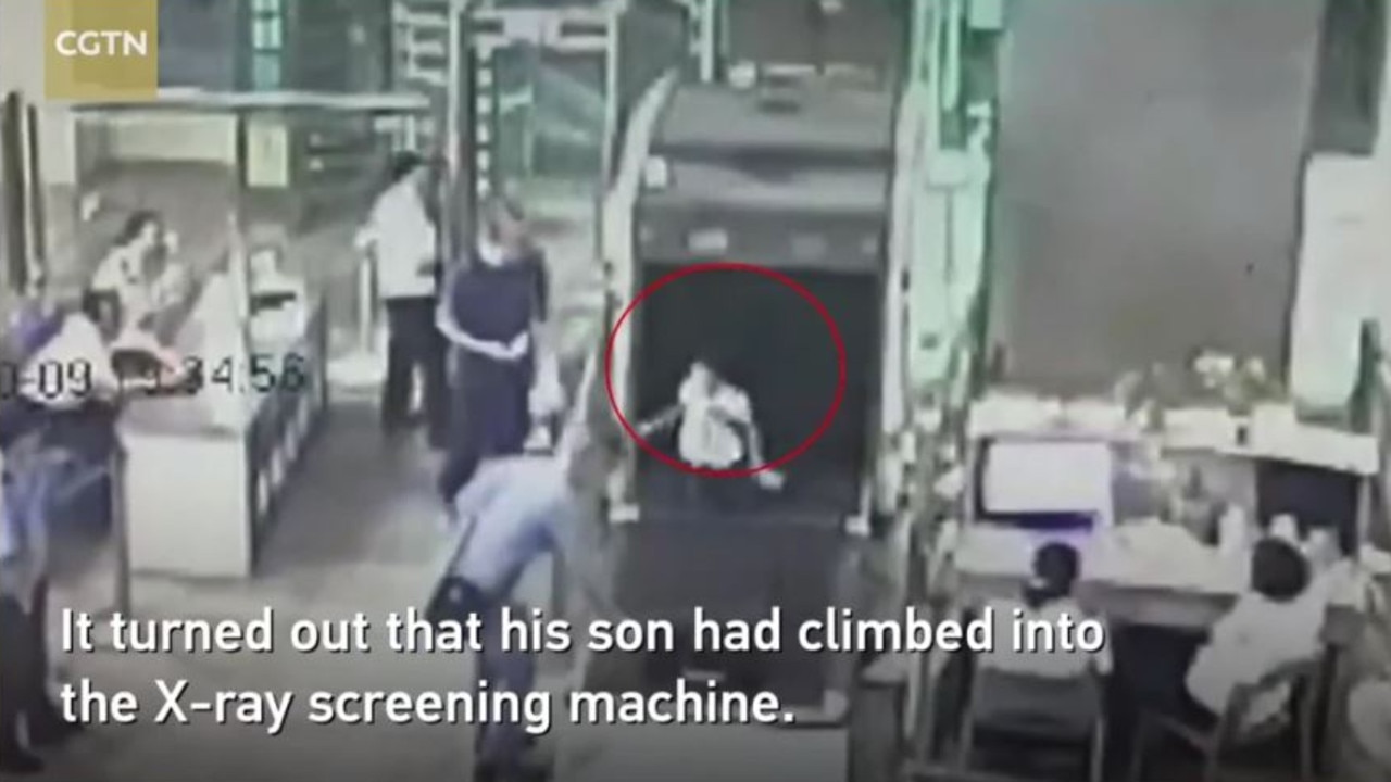 His son then emerges from the X-ray scanning machine. Picture: CGTN