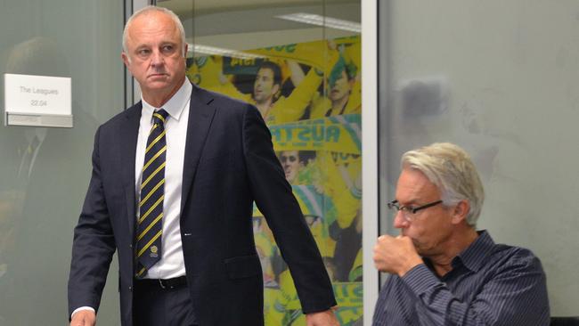 Graham Arnold walks past FFA CEO David Gallop as he arrives for his first press conference as national coach in Sydney. Picture: AFP.