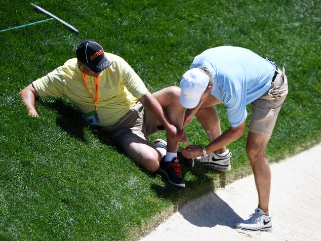 The caddie receives medical attention.