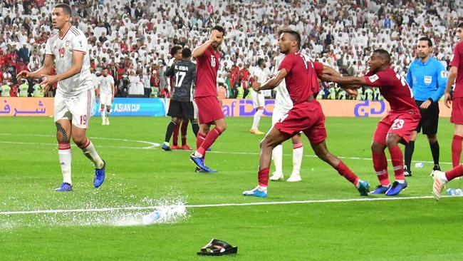 TOPSHOT - Fans throw bottles and flip-flops at the pitch during the 2019 AFC Asian Cup semi-final football match between Qatar and UAE at the Mohammed Bin Zayed Stadium in Abu Dhabi on January 29, 2019. (Photo by Giuseppe CACACE / AFP)