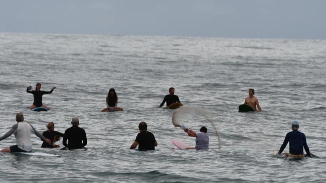 About 60 surfers entered the water at Moffat Beach on November 11 to farewell beloved board shaper and repairer Chris "Christo" Heavener. Photo: Julie Behrens