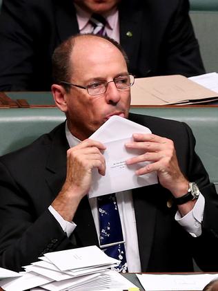 Liberal MP Luke Simpkins licking envelopes during Question Time in the House of Representatives Chamber, Parliament House in Canberra.
