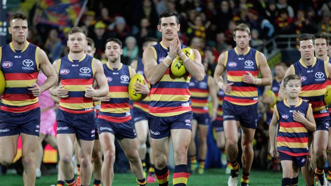 Taylor Walker leads his team on to Adelaide Oval against North Melbourne.