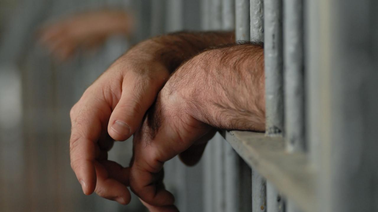 Man behind bars. Jail. Prison. Prisoner. Hands. Generic image.
