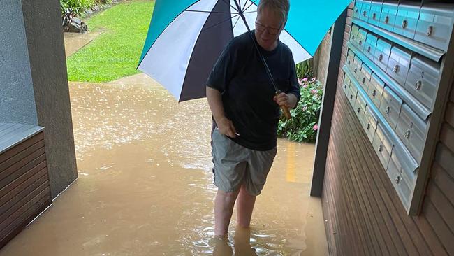 Coffs Harbour resident Chris Began wades in to check for mail.