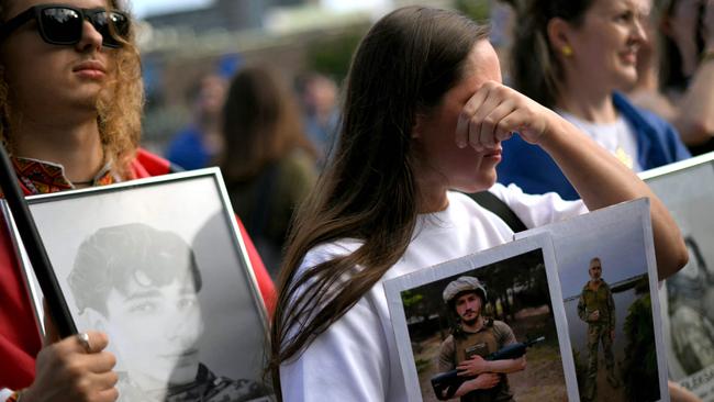 Members of the Ukrainian community in Australia react as they hold photographs during a vigil in central Sydney. Picture: AFP