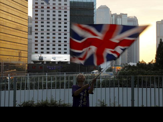 A protester waves a British flag outside the government headquarters in Hong Kong. Picture: AP