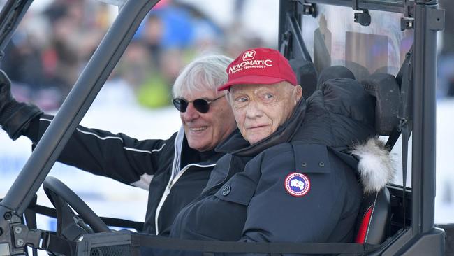 Lauda sporting his famous red cap, alongside Formula One supremo Bernie Ecclestone (L). Picture: AFP