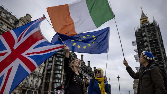 Anti-Brexit protesters wave the flags of the United Kingdom, Ireland and European Union outside parliament this month Picture: Getty Images.