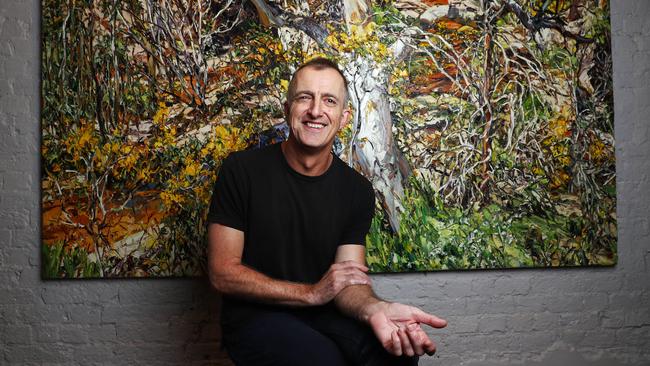 Nicholas Harding in his living room with the painting Wilpena eucalypt and wattle after his treatment for cancer. Picture: John Feder.