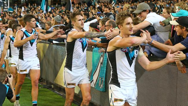 Port Adelaide players celebrate with fans at the MCG.