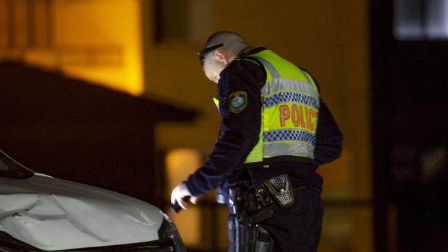 A police officer inspects the car that hit the family. Picture: Dean Asher