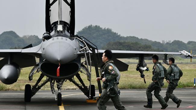 Taiwanese air force pilots run pass an armed US-made F-16V fighter at an air force base in Chiayi, southern Taiwan. Picture: AFP.