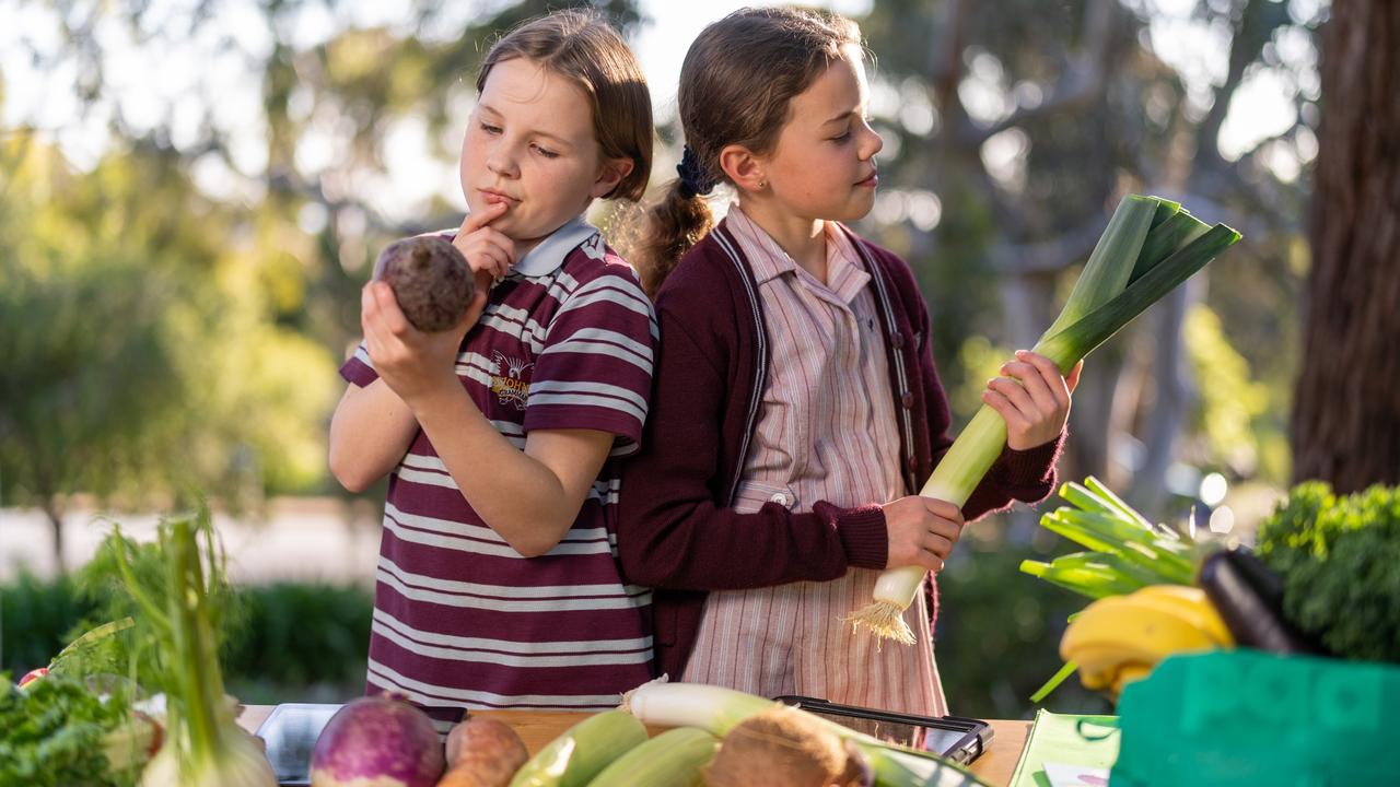 Jennifer Young and Lucy Young check out some different varieties of vegetables, including a beetroot and a leek. Picture: Adam Dormand