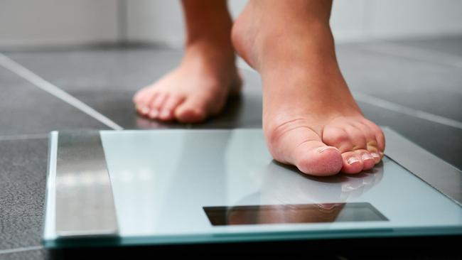 Female bare feet with weight scale in the bathroom, scales generic