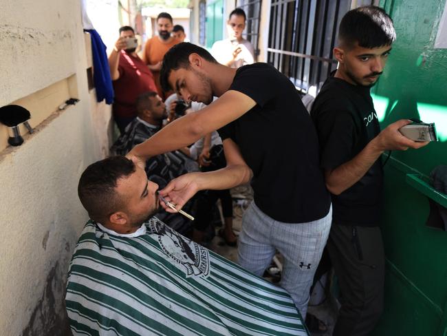 A bit of normality is offered to internally displaced Palestinians in the form of a free shave in the grounds of the Khan Yunis Hospital. Picture: Mahmud Hams/AFP