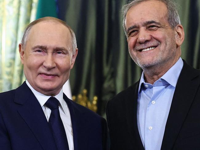 TOPSHOT - Russian President Vladimir Putin and Iranian President Masoud Pezeshkian shake hands during a meeting at the Kremlin in Moscow on January 17, 2025. (Photo by Evgenia Novozhenina / POOL / AFP)