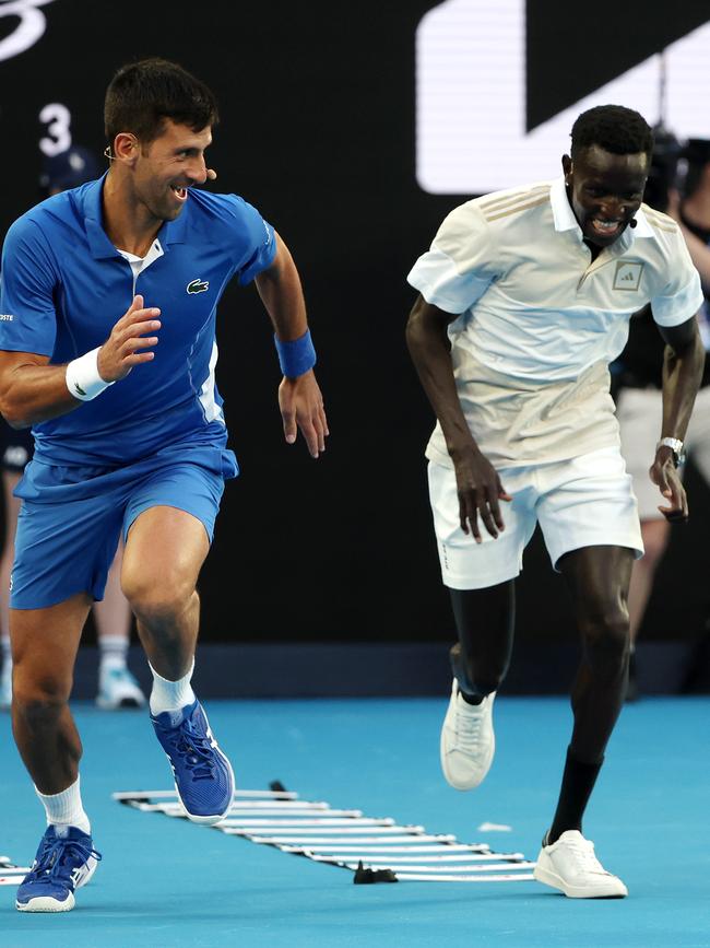 Peter Bol taking Novak Djokovic through running drills. Picture: Mark Stewart