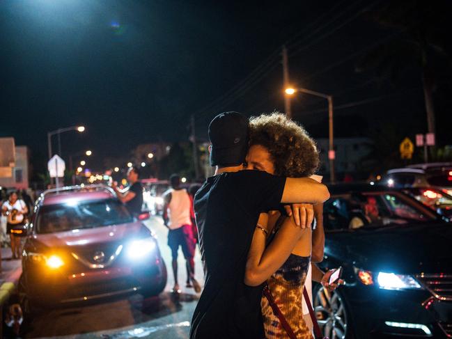 People hug as they watch the rest of the Champlain South tower being demolished. Picture: AFP