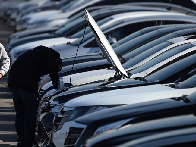 A man walks through a used car sales yard in Beijing on January 22, 2019. - China's economy grew at its slowest pace in almost three decades in 2018, losing more steam in the last quarter as it battles a massive debt pile and a US trade war, official data showed on January 21. (Photo by GREG BAKER / AFP)