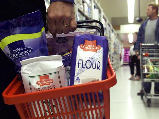 21 Sept 2004  Generic of shopper carrying shopping basket loaded with Farmland and other Coles house brand products at Coles South Melbourne supermarket. retail stores shops shop groceries shopping  shoppers plastic basket Farmland Plain Flour Farmland Pure Australian Sugar packaging trolley in b/g