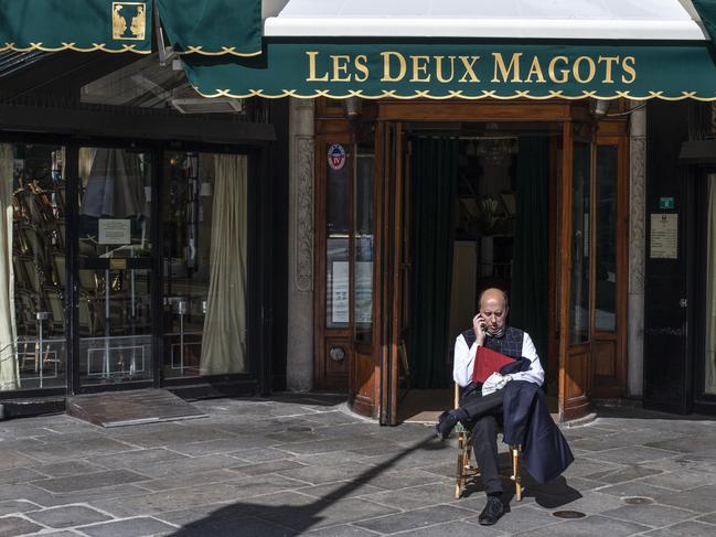 A man sits outside the closed famed Les Deux Magots cafe in Paris. Picture: AP