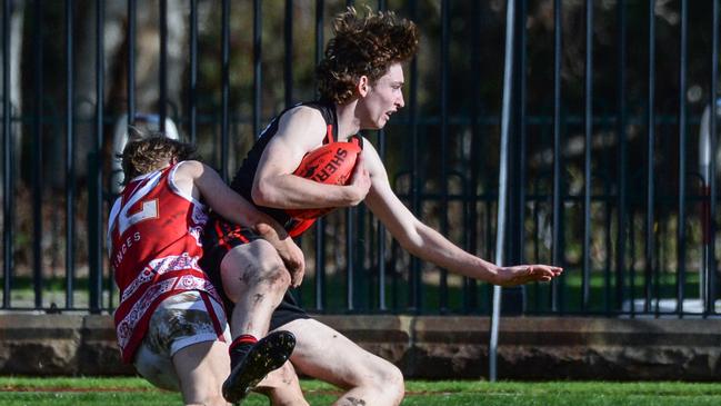 Rostrevor’s Max Michalanney is tackled by PAC’s Charlie Adams, who was a bull inside. Picture: Brenton Edwards