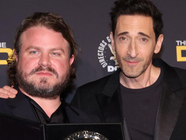 US director Brady Corbet, poses in the press room with the silver medallion for his Directors Guild of America Theatrical Feature Film nomination for "The Brutalist" with US actor Adrien Brody during the 77th Annual DGA Awards at the Beverly Hilton hotel in Beverly Hills, California, February 8, 2025. (Photo by Valerie MACON / AFP)