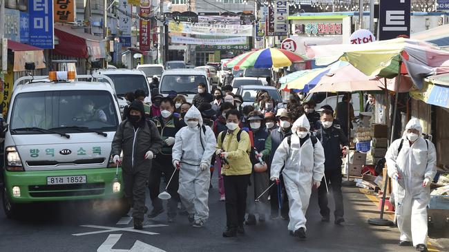 Residents spray disinfectant as a precaution against a new coronavirus at a traditional market in Suwon, South Korea. Picture: AP.