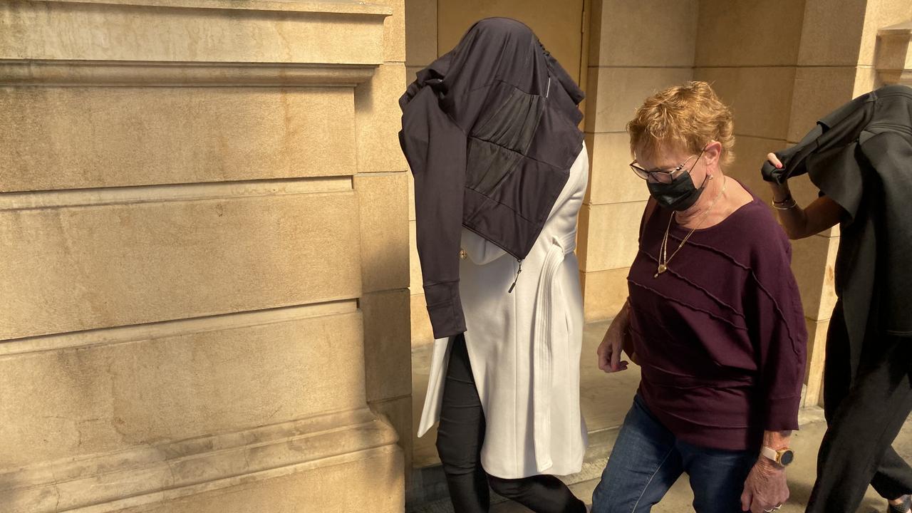 Carly Jane Wren (left) covered her head and made no comment as she left the District Court on Friday. Picture: NCA NewsWire/Kathryn Bermingham