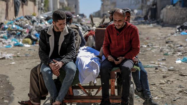 CORRECTION / TOPSHOT - The body of a Palestinian killed in an early morning incident when residents rushed toward aid trucks in Gaza City on February 29, 2024. The health ministry in Hamas-run Gaza said Israeli forces shot dead dozens of people when a crowd rushed towards aid trucks on February 29. Israeli sources confirmed that troops opened fire at Palestinians, with one saying soldiers thought they "posed a threat", and that many died when they were run over by aid trucks. (Photo by AFP) / âThe erroneous mention[s] appearing in the metadata of this photo by - has been modified in AFP systems in the following manner: [CAPTION CONTENT]. Please immediately remove the erroneous mention[s] from all your online services and delete it (them) from your servers. If you have been authorized by AFP to distribute it (them) to third parties, please ensure that the same actions are carried out by them. Failure to promptly comply with these instructions will entail liability on your part for any continued or post notification usage. Therefore we thank you very much for all your attention and prompt action. We are sorry for the inconvenience this notification may cause and remain at your disposal for any further information you may require.â