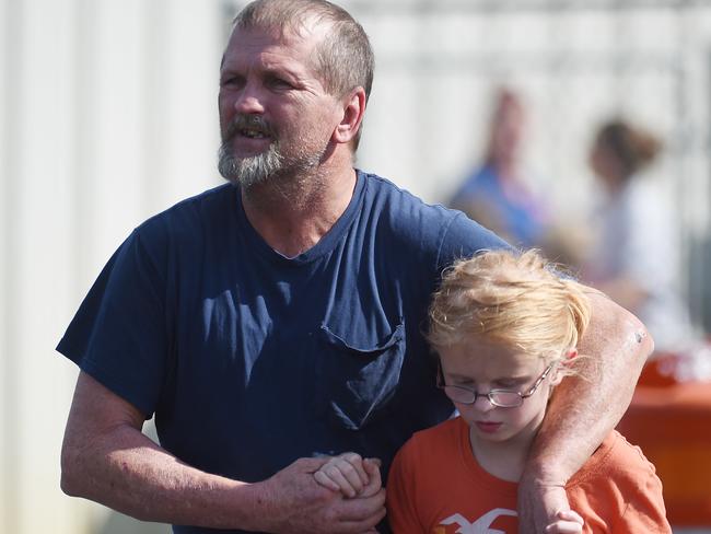 Parent Joey Taylor walks with his daughter Josie Taylor after picking her up at Oakdale Baptist Church. Picture: AP Photo/Rainier Ehrhardt