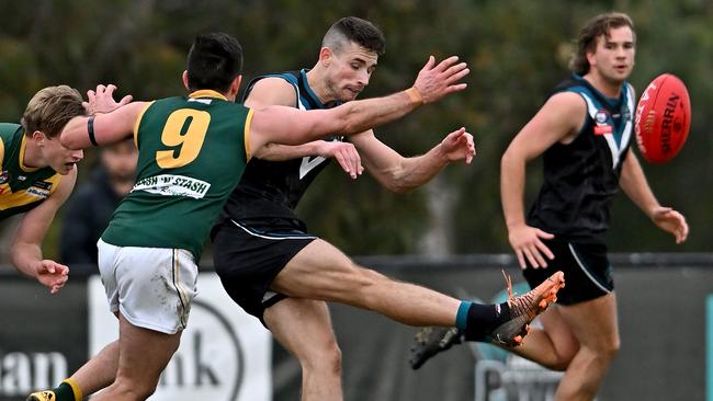 NFL: Old Eltham Collegians’ Nick Snowdon can’t stop Laurimar’s Luke Wilson getting a kick away. Picture: Andy Brownbill